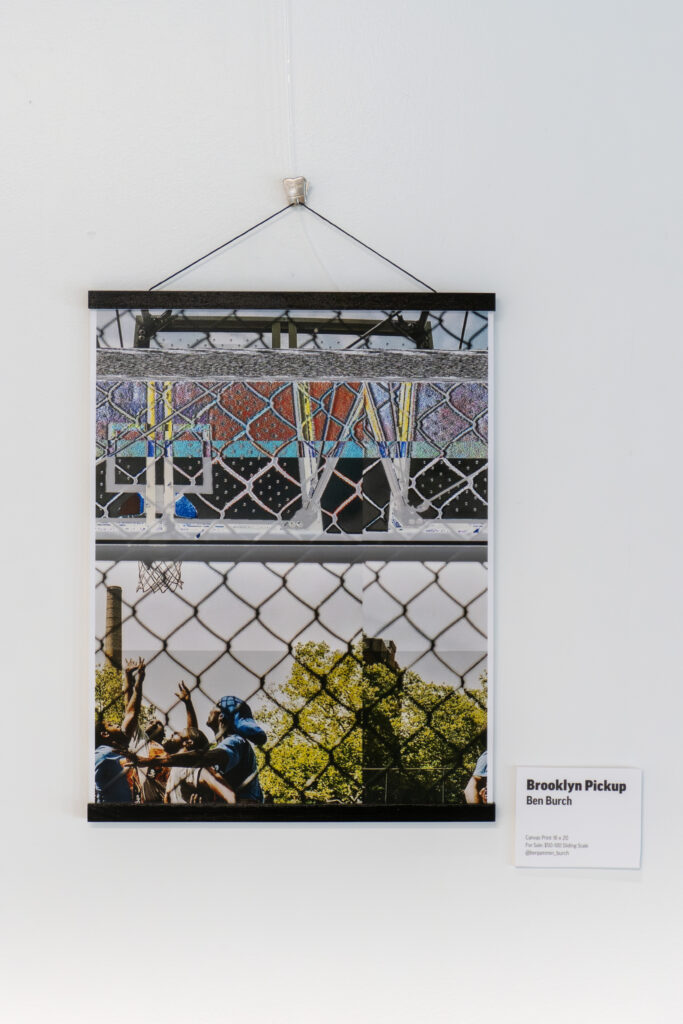 A framed photo display hangs on a white wall, showing two basketball-themed images: one of a fenced court and another of players reaching for a ball. A label beside it reads, “Brooklyn Pickup, Ben Burch”—part of DC’s vibrant Arts Community.
