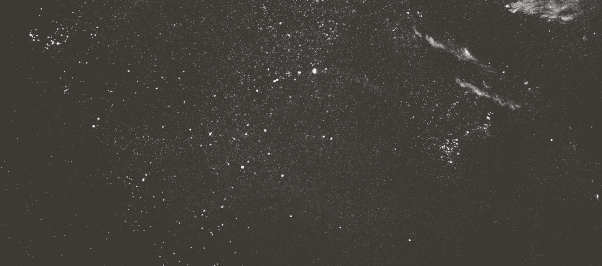 A black background scattered with small white specks and patches, resembling a starry night sky or the cosmos—much like a dreamy visual for exclusive memberships—with a few cloudy, textured areas on the right side.